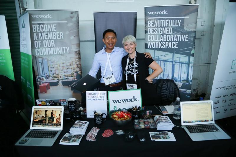 People working at the WeWork exhibit table at TechCrunch Disrupt NYC 2017